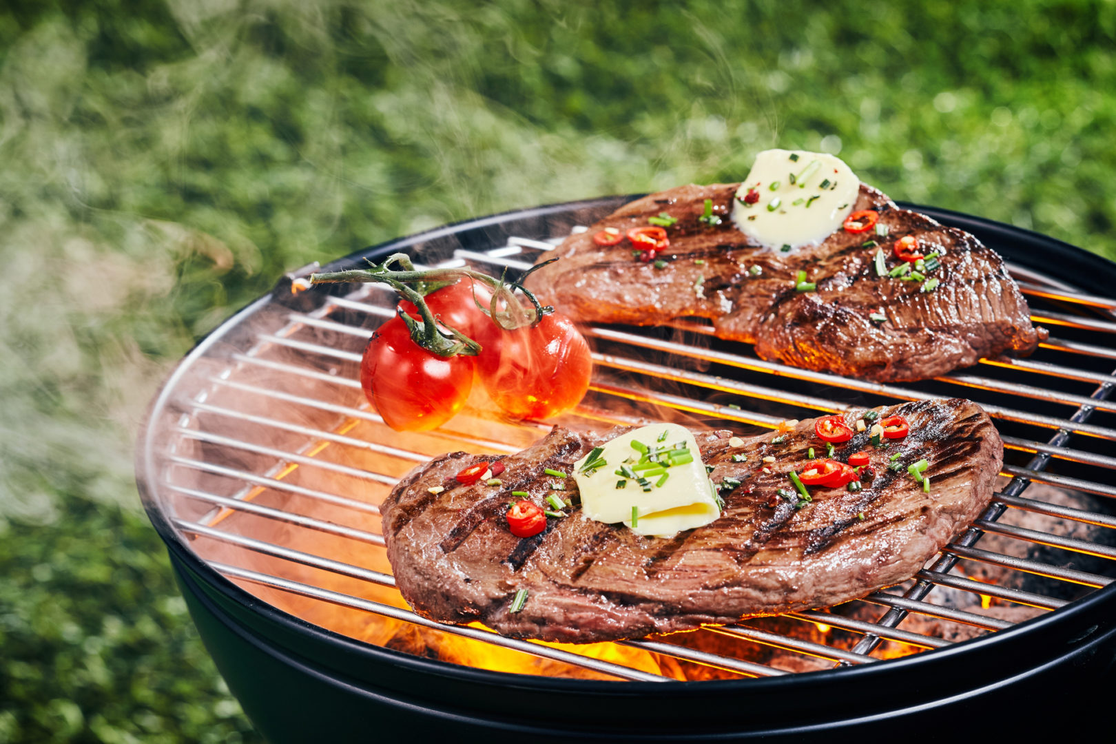 Two tender portions of rump steak grilling on a barbecue fire