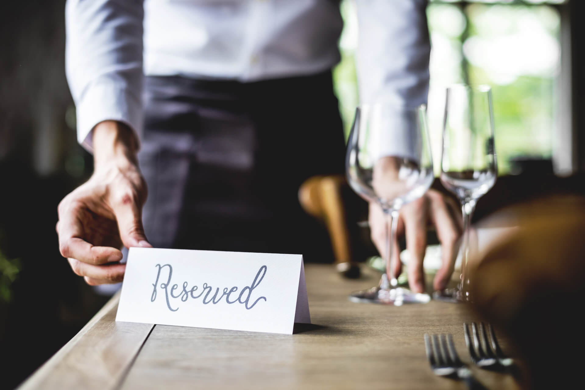 Waiter Setting Out Reservation Notice In Dallas Steakhouse